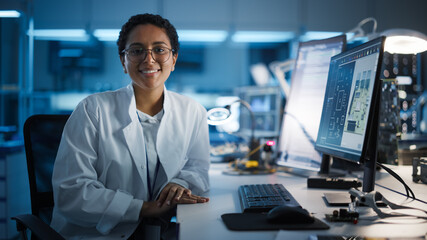 Beautiful Black Latin Woman Wearing Glasses Smiling Charmingly Looking at Camera. Young Intelligent Female Scientist Working in Laboratory. Technological Laboratory in Bokeh Blue as Background - Powered by Adobe