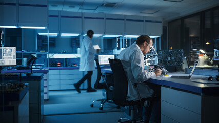 Modern Electronics Research and Development Facility: Intelligent Caucasian Male Engineer Does Computer Motherboard Soldering. Scientists Design Industrial PCB, Silicon Microchips, Semiconductors