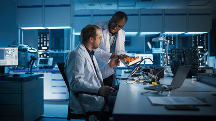 Electronics Research, Development Facility: Engineer Project Manager Consults Scientist Working on...