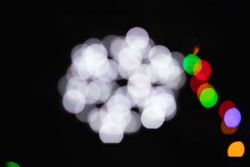 Abstraction in the form of a flower of white dots on a dark background. Out of focus.