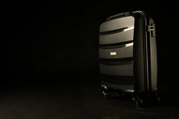 Holiday suitcase prepared on black background, holiday concept, place for text.