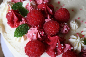 Birthday cake with cream and fresh raspberries