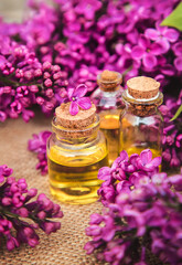 Obraz na płótnie Canvas Lilac essential oil in a small bottle. Selective focus.