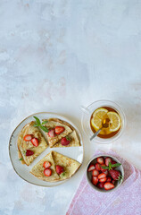 Crepes, thin pancakes with fresh strawberries. Top view.