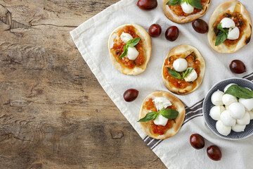 Homemade mini pizzas margarita with tomato, mozzarella and basil