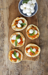 Homemade mini pizzas margarita with tomato, mozzarella and basil