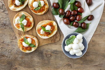 Homemade mini pizzas margarita with tomato, mozzarella and basil