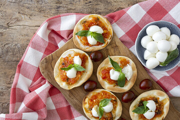 Homemade mini pizzas margarita with tomato, mozzarella and basil