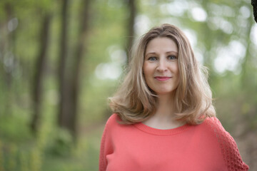 Fototapeta premium Portrait of a young beautiful blonde woman in a summer forest.