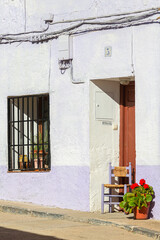 Facade of old house with wooden chair at the door, next to a pot of geraniums in Fuendetodos, hometown of Spanish painter Francisco De Goya, Zaragoza, Spain