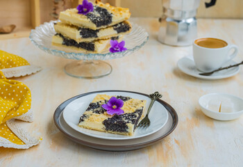 Sliced pie with cottage cheese and poppy filling on shortcrust pastry on a ceramic plate on a light wooden background. Poppy pies.