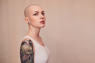 Bald masculine woman posing fashionably with serious emotions - obrazy, fototapety, plakaty