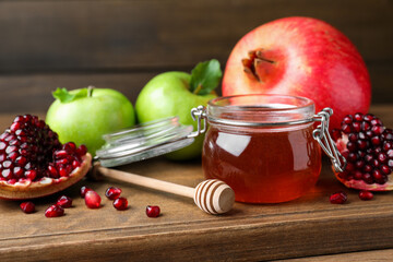 Honey, pomegranate and apples on wooden table, closeup. Rosh Hashana holiday
