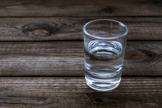 Shot of vodka on an old wooden table. Close up view