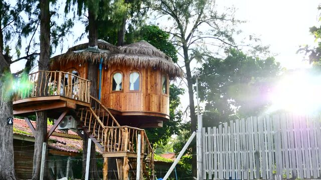 Unusual Wooden Treehouse with Rays of Sunset on Background. Designer Housing on Tropical Island. Unique Resort with Luxurious Tree House for Travelers. 4k