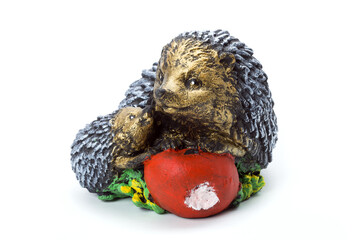 family of hedgehogs with red apple concrete garden sculpture for landscaping and backyard decoration, isolated stone object on white background, nobody.