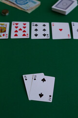 playing cards and chips.online poker games. two black cards in game in casino. playing cards with blue deck on the green table. combination of cards on a green casino desk background with copy space.