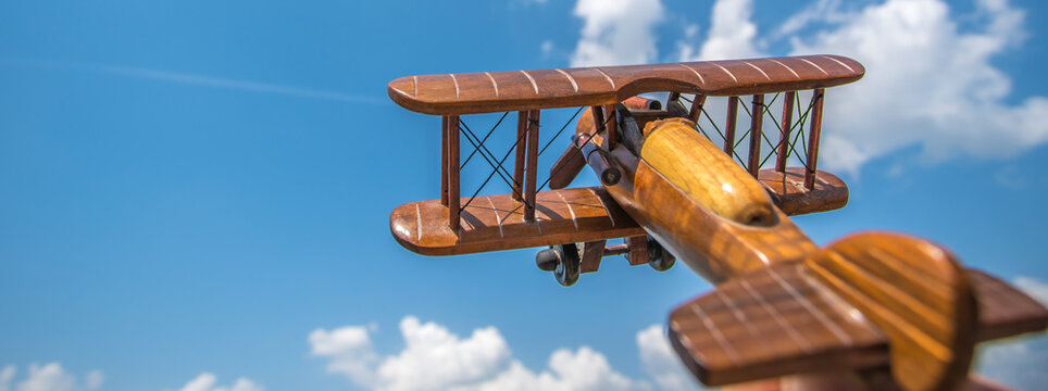 The wooden airplane fly on the cloud background