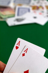 two red aces. playing cards with blue deck on the green table. combination of cards on a green casino desk background.copy space. vertical