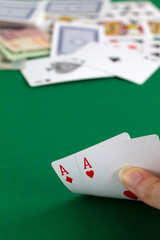 playing cards in the casino.hand shows a two aces. playing cards with blue deck on the green table. combination of cards on a green casino desk background.copy space. vertical