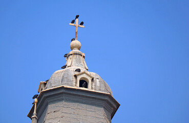 Fototapeta na wymiar Flock of Condors Perching on the Cross of Lima Cathedral's Bell Tower, the Historic Center of Lima, Peru