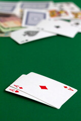 poker cards and chips.two red aces. playing cards with blue deck on the green table. combination of cards on a green casino desk background. top view. vertical