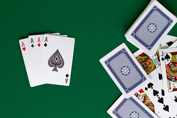 four aces. playing cards with blue deck on the green table. combination of cards on a green casino desk background. poker. top view.