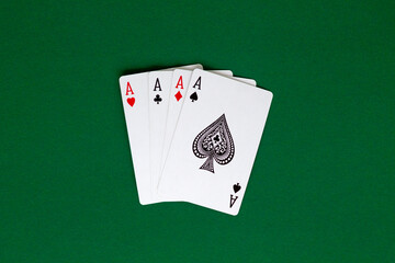 four aces. playing cards with blue deck on the green table. combination of cards on a green casino desk background. poker. top view.