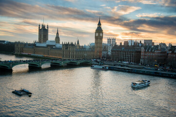 London, UK - February 4, 2017: London skyline view at sunset with famous landmarks, Big Ben, Houses of Parliament and ships on River Thames with beautiful blue and yellow sky.
