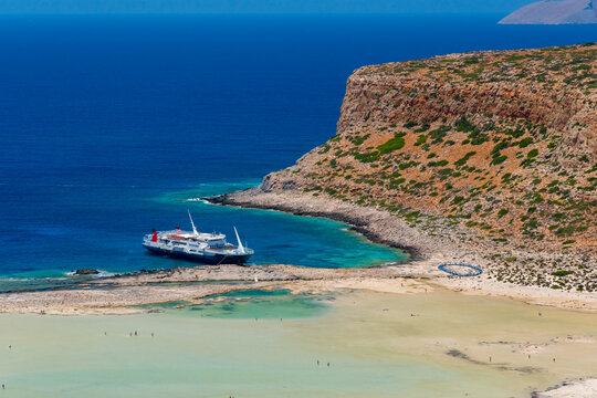 Cruse ship on amazing beach with turquoise water at Balos Lagoon and Gramvousa in Crete, Greece. Cap tigani in the center. magical turquoise waters, lagoons, tropical beaches of pure white sand.