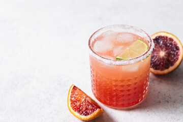 Blood orange margarita cocktail on white table background. Summer cocktails, refreshing drinks,...