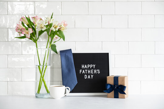 Happy Fathers Day Concept. Letterboard With Sign Happy Father's Day, Gift Box, Flowers On Table.