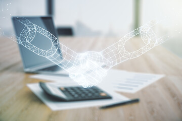 Abstract virtual blockchain technology hologram with handshake on calculator and laptop background....