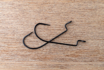 Two offset worm bait hooks on a wood background.