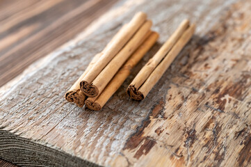 Cinnamon sticks on the wooden background - obrazy, fototapety, plakaty