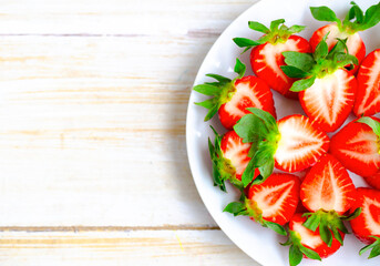 Ripe Strawberries in a White Plate. Fresh Juicy Strawberries with Leaves. Summer Berries Background.