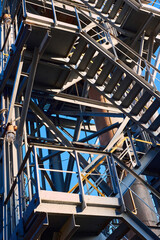 Industrial building structure fragment featuring metal staircases tubes and pillars. Abstract image concept of modern urban architecture industry and technology, vertical.