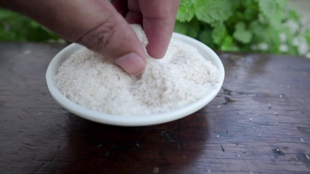Checking Psyllium husks by finger on small plastic pot top view