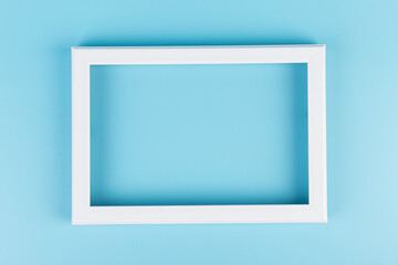 Rectangular blank white picture frame on the blue  background. mockup