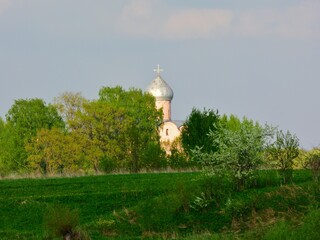 The dome of the church against the backdrop of the river and green trees