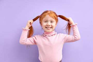 Cheerful Kid Girl Have Fun, Holding Two Tails In Hands, Smiling At Camera, Happy Excited Child With Natural Red Hair