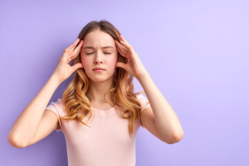 Young girl stand thinking touching temples with eyes closed, concentrated on thoughts, isolated over purple studio background