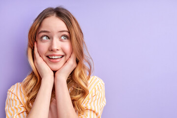 Portrait of charming beautiful cute sweet lovely tender gentle with long smooth wavy hair isolated on purple background, looking at side with dreamy surprised face