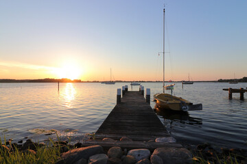 Romantic jetty with sailboat at the dreamy fishing village Maasholm with the Schlei Fjord.