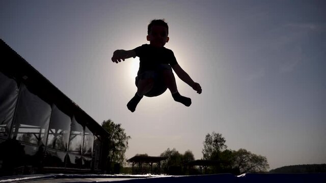 baby boy jumping having fun on a trampoline standing on the street