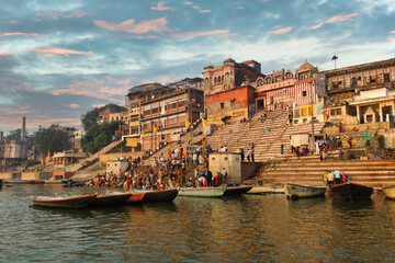 Varanasi, India: Crowd of people tourist and pilgrims in Kedar ghat participating in holy rituals and prayer in the bank of Ganges river against old architecture and cityscape