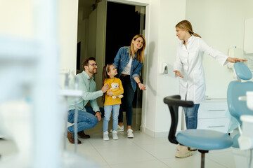 Female dentist greets the patients nicely and shows the girl where to sit.