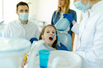 Little girl is not afraid to show teeth to dentist. Prophylactic examinations child at dentist.