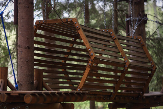 Sports park in the forest.Extreme outdoor recreation.Wooden elements,steps and ropes make up the route between the trees.Hanging ladders in the rope park.Rope park for children and adults