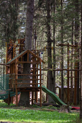 Fototapeta na wymiar Rope park in the middle of the forest.Passing sports obstacles above the ground.Outdoor activities.Sports park for the whole family.Hanging steps and ropes strung between trees.Wooden Town 